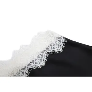 Detailed macro shot of delicate white floral lace trim on a sexy black camisole top