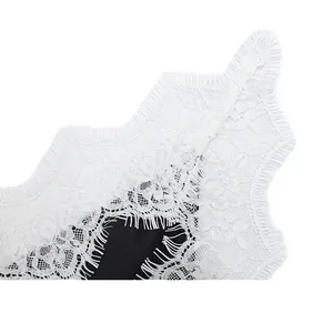 Detailed view showing the intricate texture of white eyelash lace on a black camisole