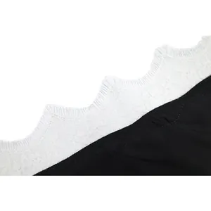 Close-up of white lace trim on black sexy camisole showing delicate fabric detail