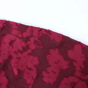 Makro-Detail des hochwertigen bordeauxroten floralen Jacquard-Stoffs für ein Abendkleid