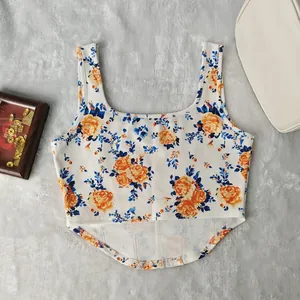 Dettaglio di un crop top con stampa floreale, scollo quadrato e orlo curvo di design.