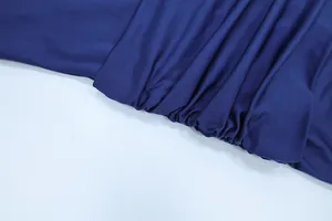 Dettaglio ravvicinato che mostra il tessuto pieghettato e la trama arricciata dell'abito blu