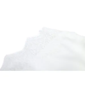 Detailed close-up view of delicate white floral lace trim on a sexy summer camisole top
