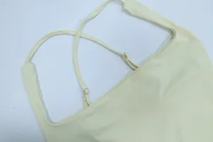 Dettaglio delle spalline incrociate regolabili su un elegante abito a sottoveste giallo