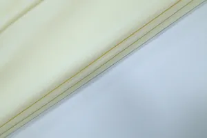 Primo piano dell'elegante trama del tessuto plissettato crema per abiti primaverili