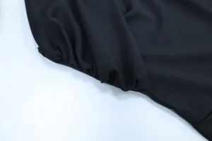 Detailaufnahme eines schwarzen Neckholder-Kleids mit exquisiter geraffter Stofftextur
