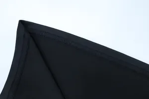 Makroansicht der präzisen Nähte und Stofftextur eines schwarzen Halterneck-Kleides