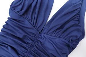 Detailed macro shot showing the ruched fabric and deep V-neckline of a navy blue dress