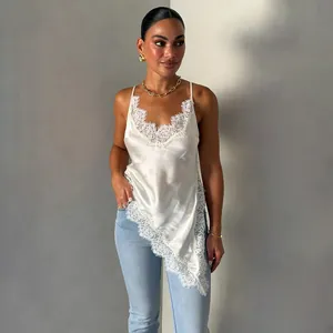 Close-up of white satin camisole with delicate lace trim and asymmetrical hem
