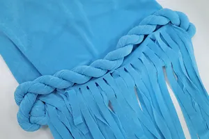 Primo piano di un abito blu con elegante cordoncino intrecciato e lunghe frange