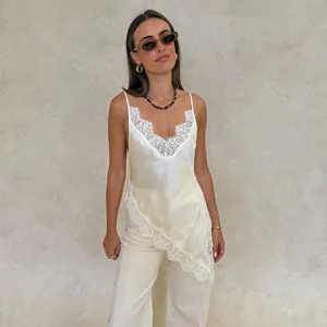 Elegant white satin camisole featuring delicate lace trim and an asymmetrical hemline.
