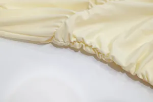 Close-up of the gathered pleated fabric detail on an elegant yellow halter dress