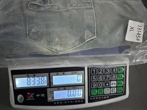 Foto di misurazione del peso di jeans in denim lavato e usurato a gamba larga su bilancia