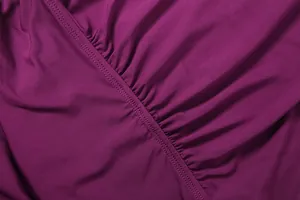 Macro detail of purple dress fabric showing fine stitching and gathered texture