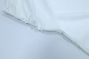 Detailansicht des weißen drapierten Stoffes an einem ärmellosen Neckholder-Kleid