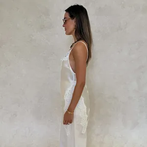 Side view of sexy champagne silk camisole with white lace trim and open back design