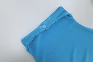 Primo piano del tessuto a costine blu vivace con un bottone rivestito coordinato