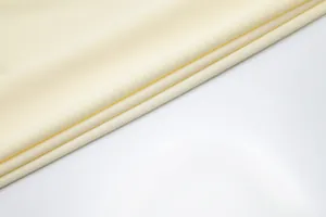 Close-up view showing the elegant cream ribbed fabric texture for an evening dress.