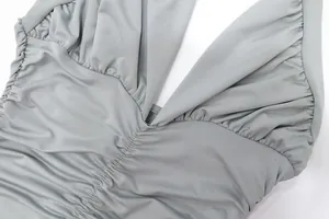 Detailed view of gray halter neck dress bodice with elegant ruched fabric texture.