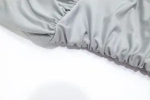 Close-up of ruched elastic waist fabric detail on an elegant light grey cocktail dress