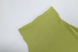 Vista macro dettagliata del tessuto a maglia a coste verde chiaro di un abito a lupetto