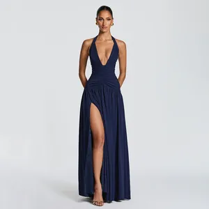 Navy blue halter neck evening gown with ruched waist and high thigh slit detail.