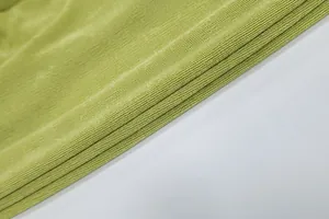 Vista macro dettagliata della trama del tessuto plissettato verde per un abito halter