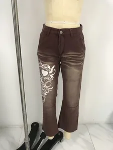 Vue détaillée d'un jean flare marron délavé avec imprimé cœur tribal blanc style rue.