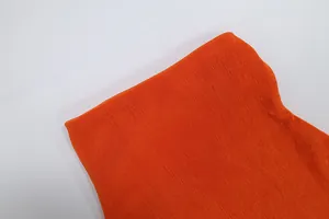 Dettaglio macro della trama del tessuto a coste arancione di un abito all'americana