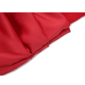 Dettaglio ravvicinato della trama del tessuto rosso di un abito aderente elegante
