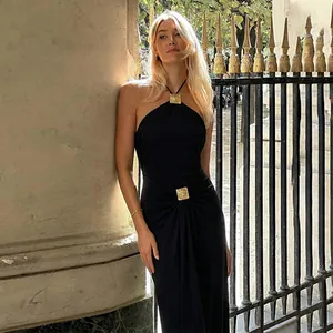 Elegantes rückenfreies schwarzes Neckholder-Kleid mit stilvollen goldenen Metallschnallen