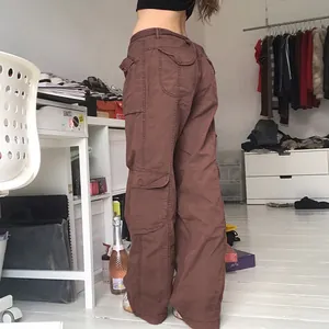 Vue détaillée du pantalon cargo marron vintage à jambes larges avec plusieurs poches à rabat.