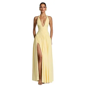 Elegant pale yellow halter neck maxi dress with high slit and plunging V-neck.