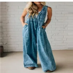 Wide-leg washed denim jumpsuit featuring a sleeveless pleated bodice and functional pockets.