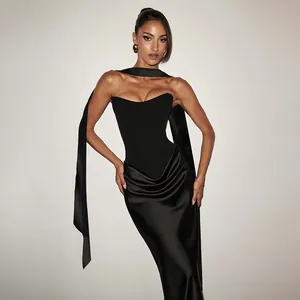 Dettaglio dell'elegante abito nero senza spalline con drappeggio in raso e fusciacca lunga.