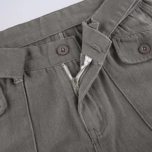 Close-up detail of vintage grey cargo pants waist with metal zipper and button closure.