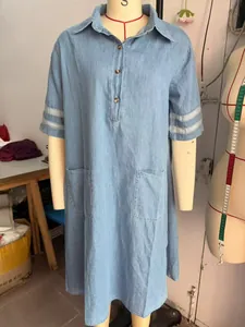 Detail view of denim washed shirt dress with mesh sleeves and front pockets
