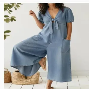 Detailed view of women's casual washed denim jumpsuit with V-neck tie and wide leg