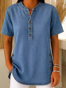 Close-up detail of women's casual washed blue denim short sleeve shirt with buttoned V-neck