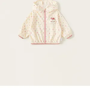 Detailed view of cream hooded windbreaker jacket for girls featuring colorful polka dots
