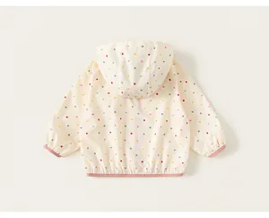 Detailed back view of a children's hooded windbreaker jacket with colorful polka dots
