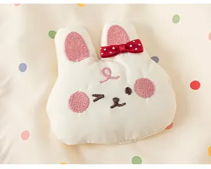 Close-up of cute 3D bunny applique with red bow on polka dot children jacket detail.
