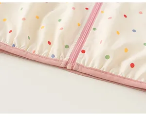 Close-up detail shot of pink zipper and colorful polka dots on a girl's windbreaker jacket
