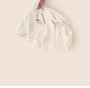 Detailed view of a girl's polka dot windbreaker with a matching cream fleece liner.
