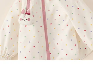 Detail view of girl's polka dot windbreaker with cute plush rabbit attachment and pink zipper