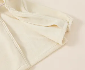 Close-up detail showing the soft texture and neat hem of a beige toddler fleece jacket
