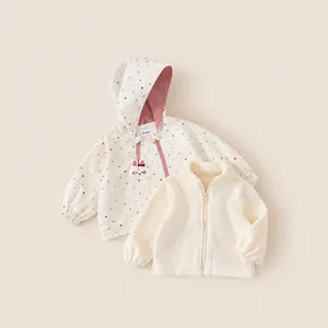Detail view of girls' polka dot windproof hooded jacket and cream fleece liner