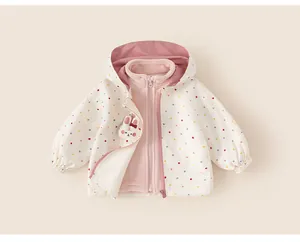 Close-up detail of a girl's white windbreaker featuring colorful polka dots and a cute rabbit