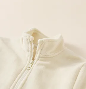 Detailed view of the stand-up collar and smooth zipper on a cream fleece jacket
