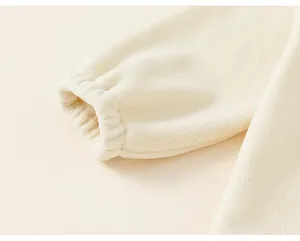 Close-up macro detail of the elasticated sleeve cuff on a cream windproof fleece jacket for girls